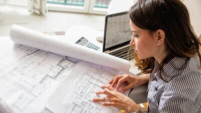 Engenheira ou arquiteta analisando uma planta baixa